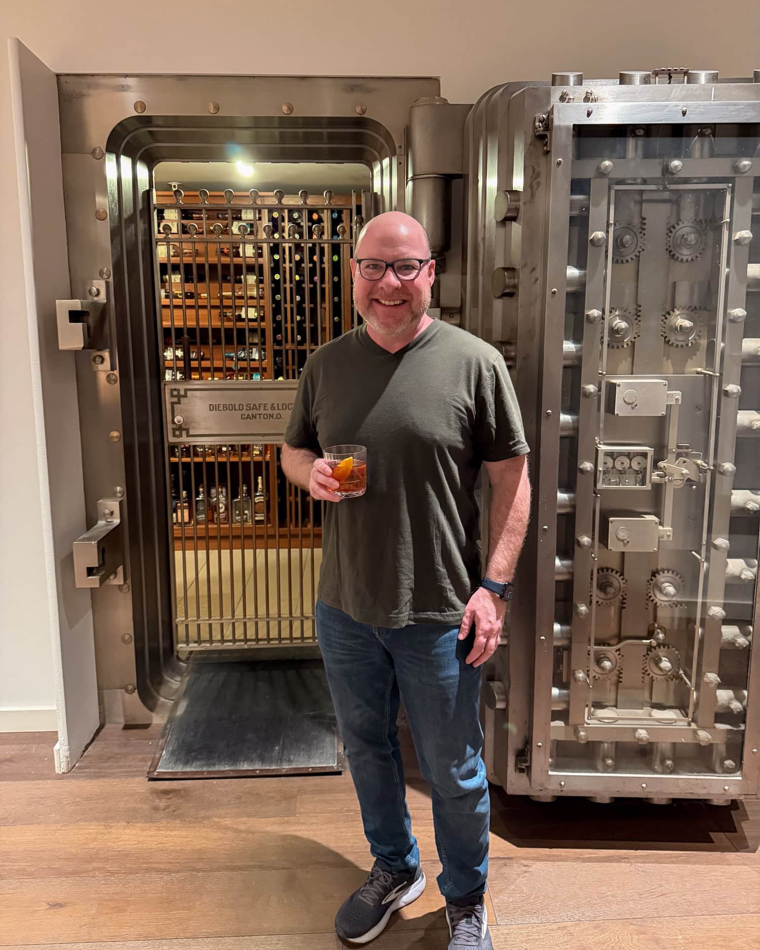Dave holding a cocktail beside the historic bank vault at Stock & Bond in Minneapolis