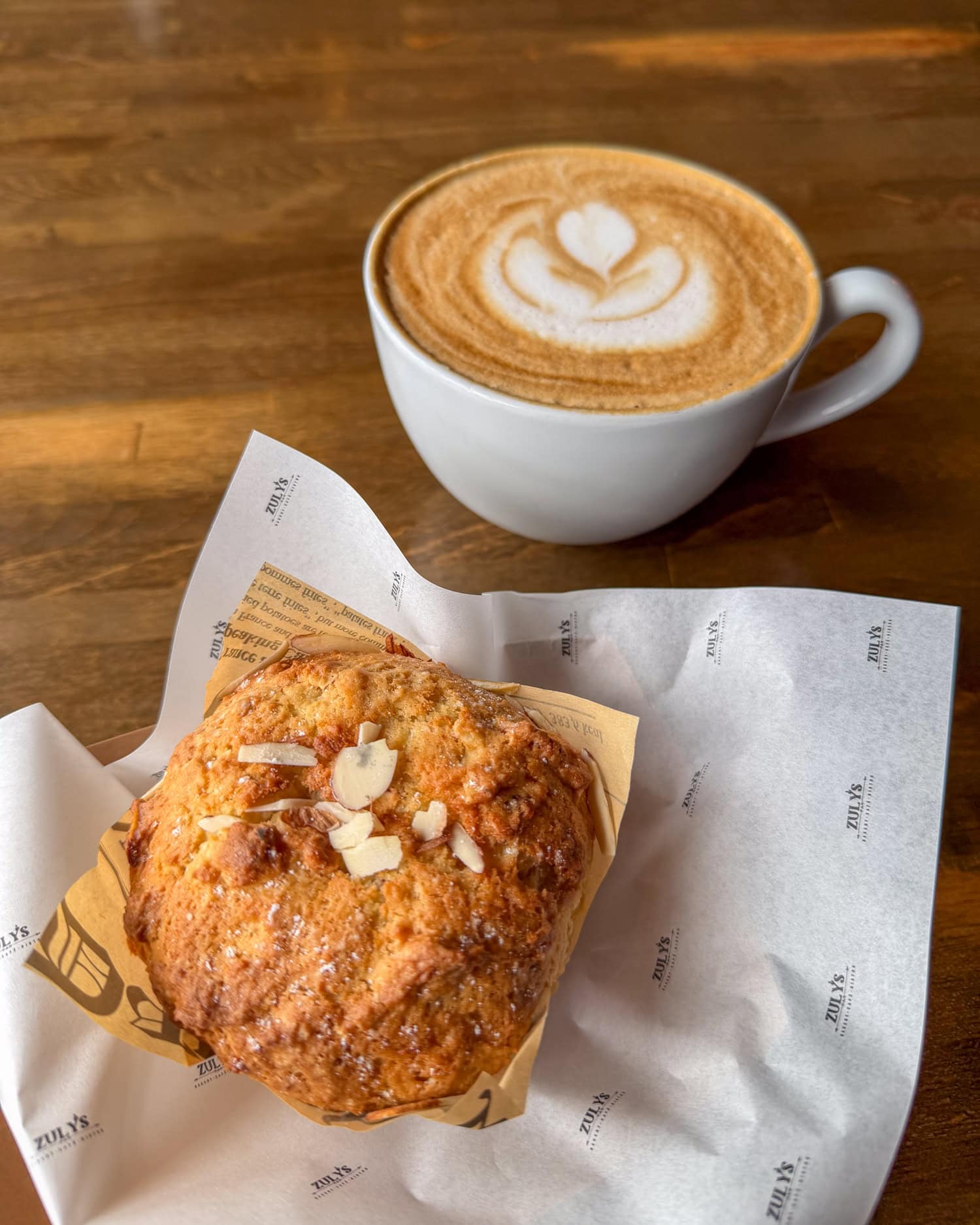 Orange-almond muffin and latte with foam art at Zuly's Bakery in Fredericksburg