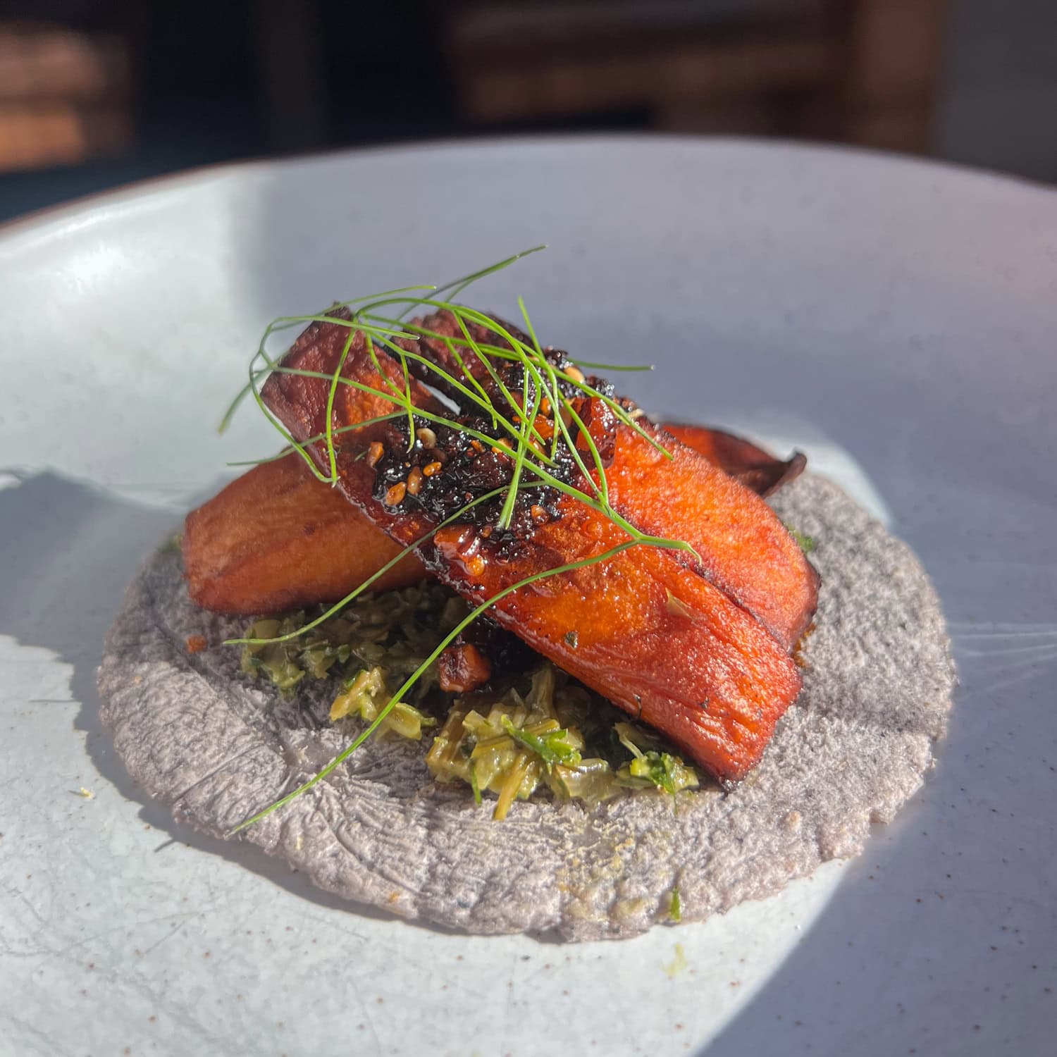 Sweet potato wedges with smoked fennel salpicon and salsa macha on a blue corn tortilla at Comedor, a modern Mexican restaurant in downtown Austin.