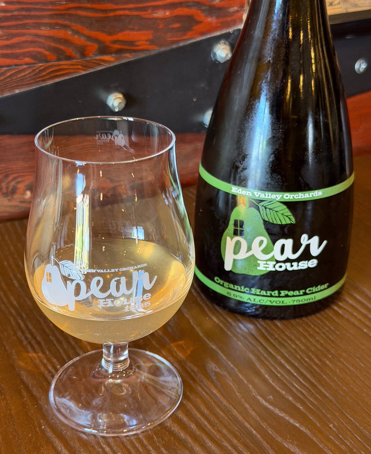 Glass of Full Pear cider beside its Pear House bottle at Edenvale Winery